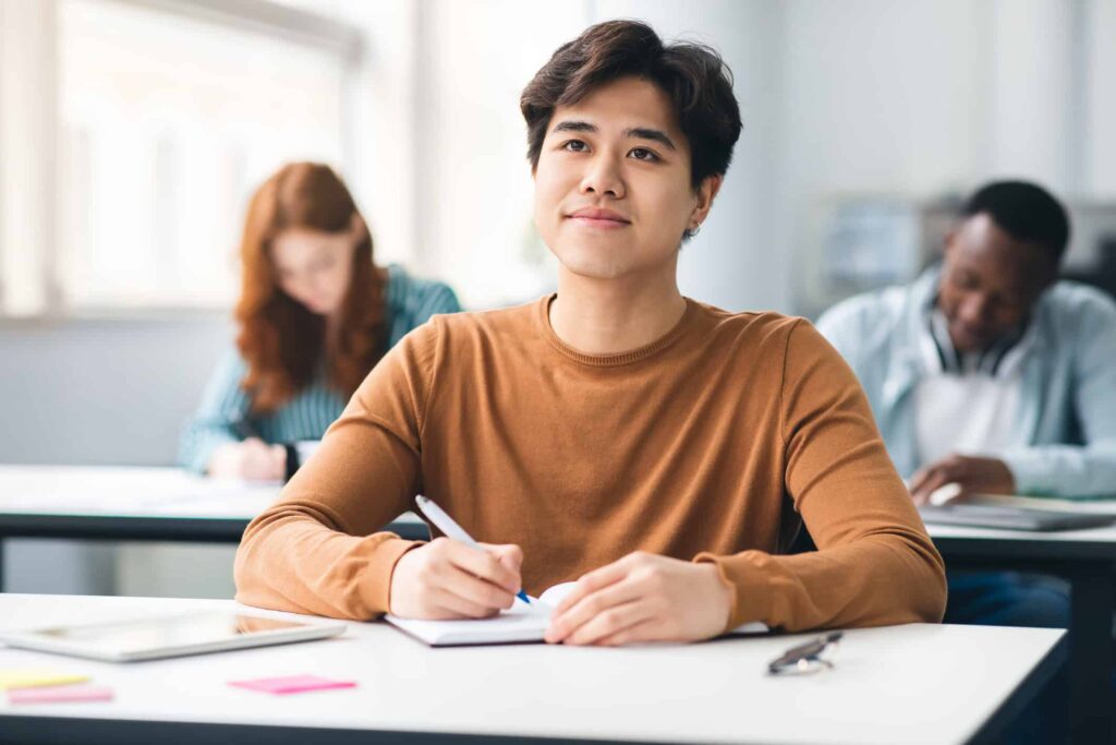 A male student in a classroom, studying for GED Social Studies exam