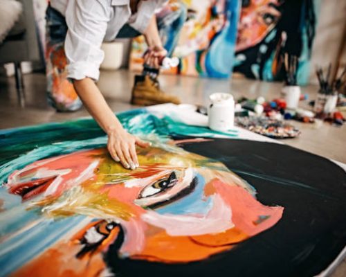 A young Asian artist working in her studio during the summer career camp with The Advisor Academy.