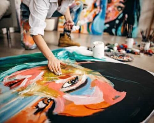 A young Asian artist working in her studio during the summer career camp with The Advisor Academy.